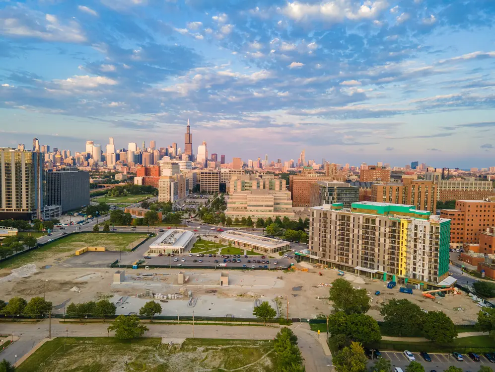 Aerial drone view of the Chicago skyline and Willis Tower at golden hour, with new apartment construction in the foreground