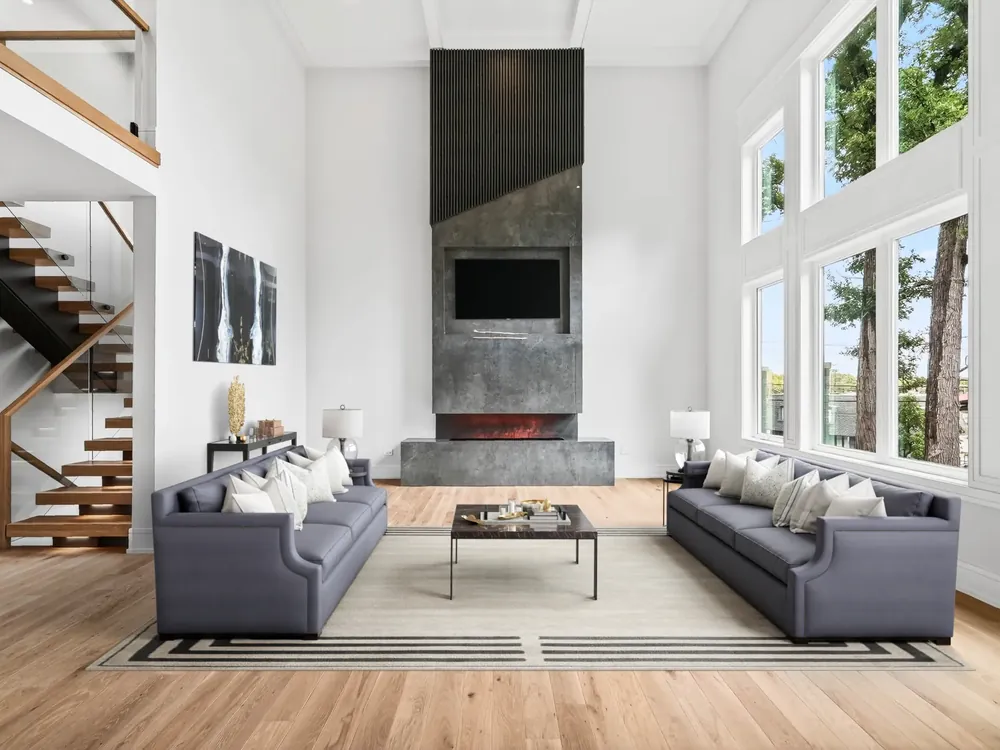 Bright, uncluttered living room with tall windows and a modern fireplace, ready for real estate photos